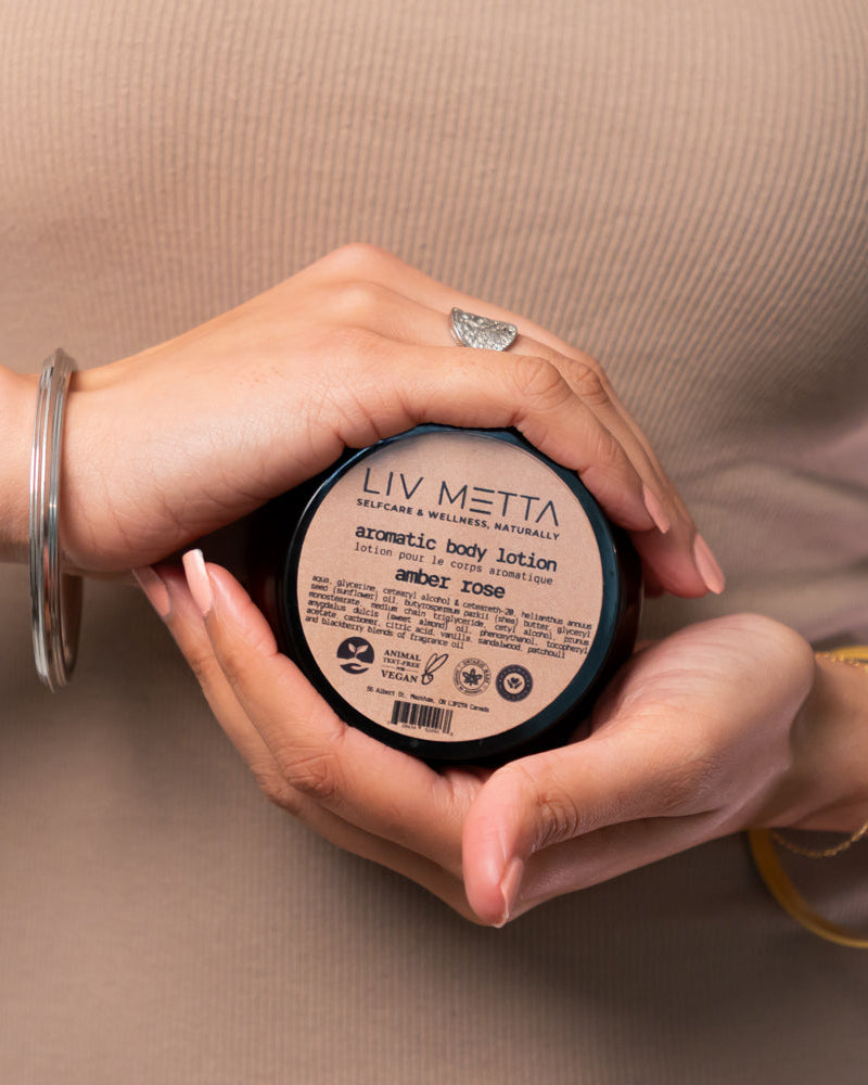 A person holding a container of Aromatic Body Lotion in their hands.