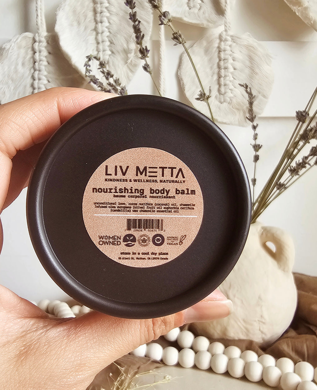 woman hand holding a body balm tub
