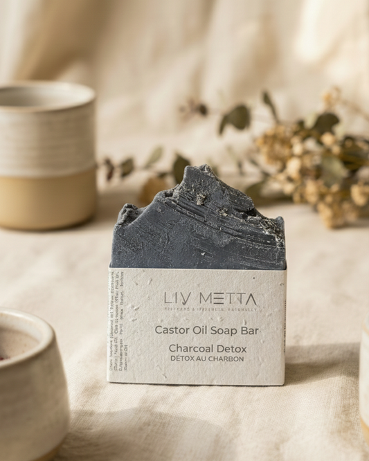 LIV METTA Charcoal Detox soap bar on a neutral background with decorative elements.