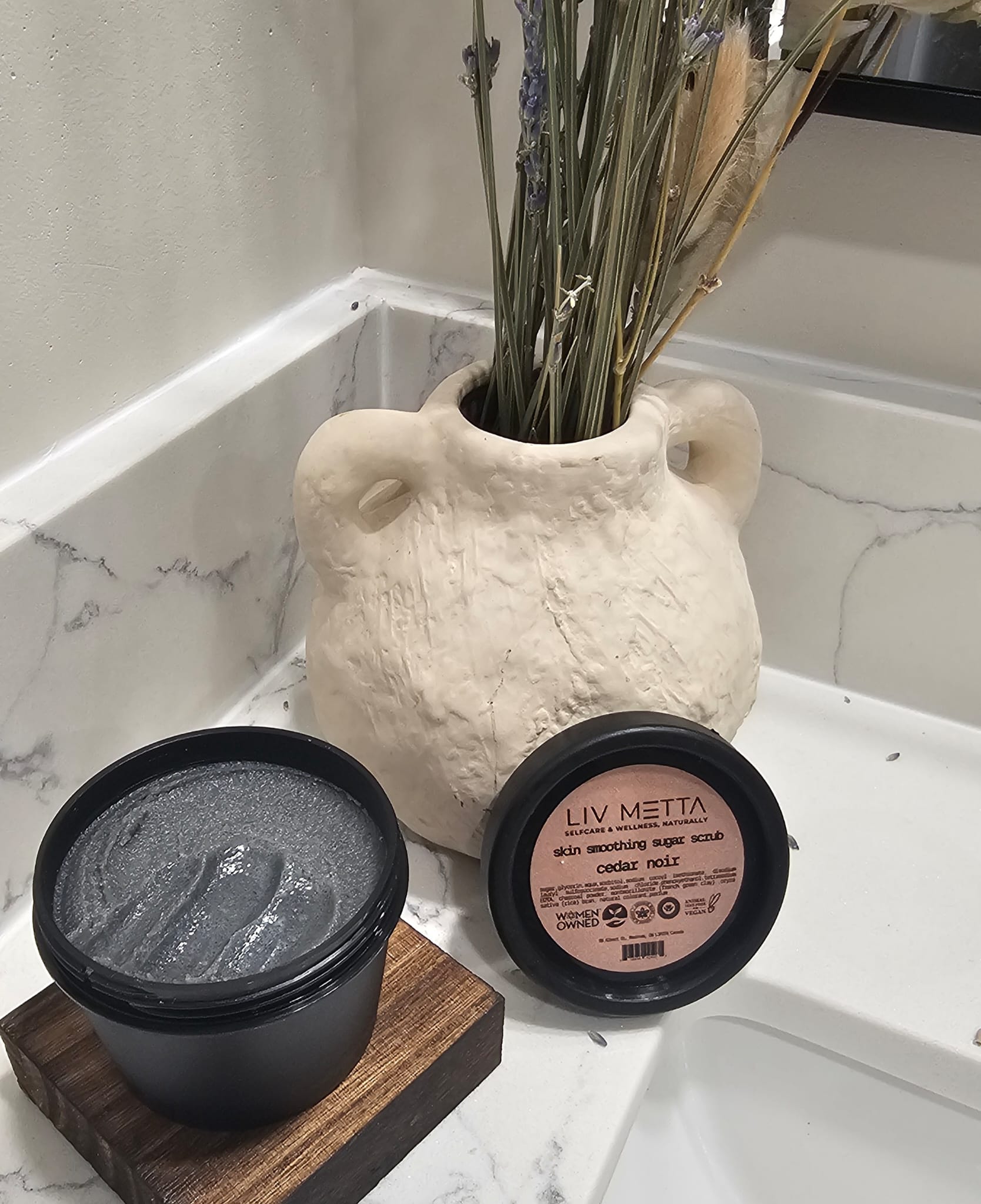 Cedar Noir Liv Metta skin washing泥膜 on a bathroom counter with a decorative vase.