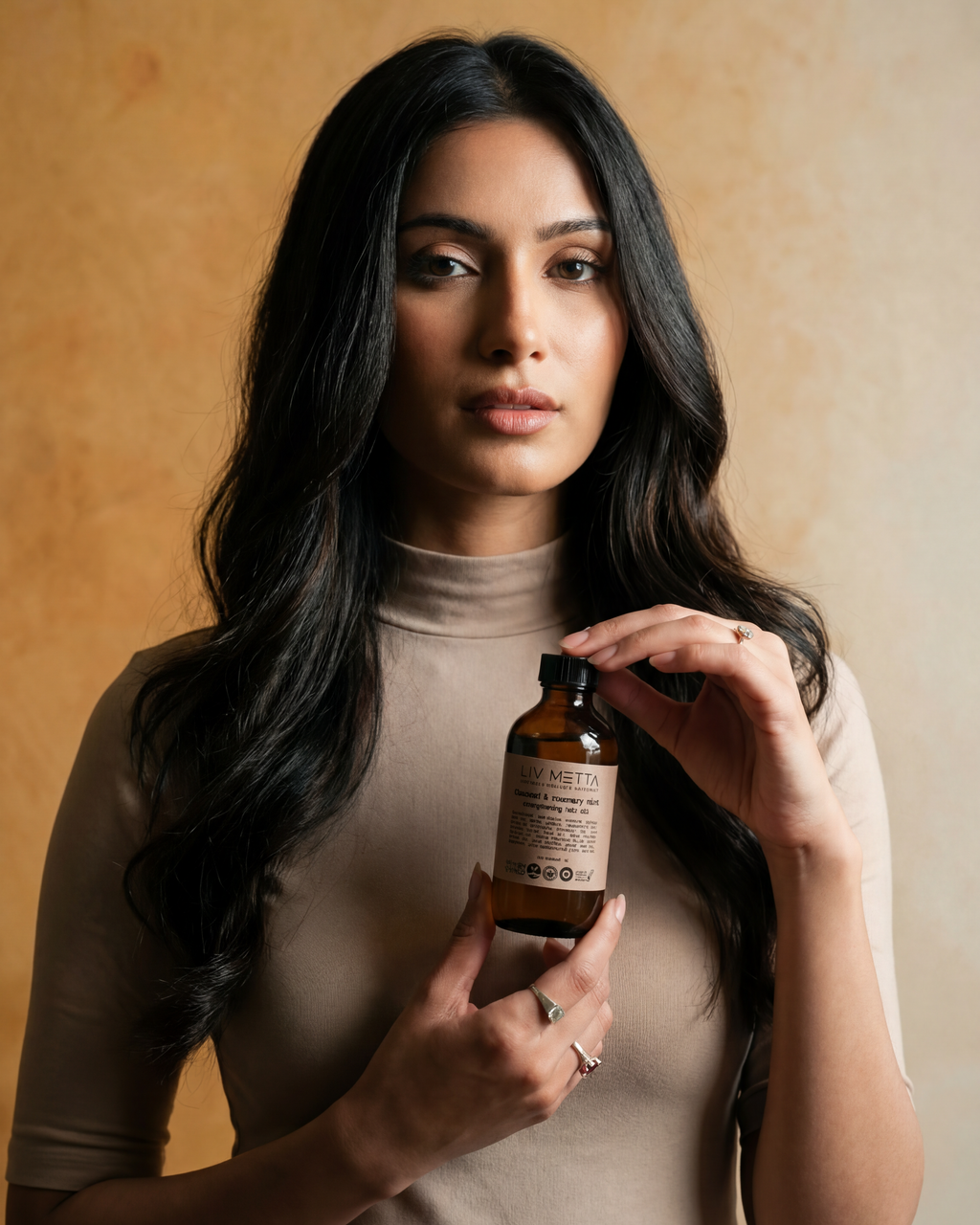 Woman holding a bottle against a beige background