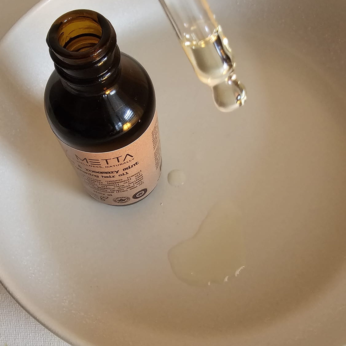 Bottle with a dropper and oil in a plate