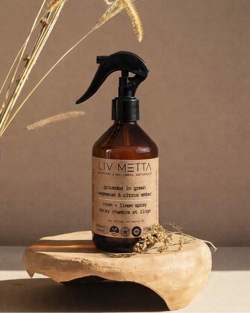 Brown spray bottle with a label on a wooden surface against a brown background