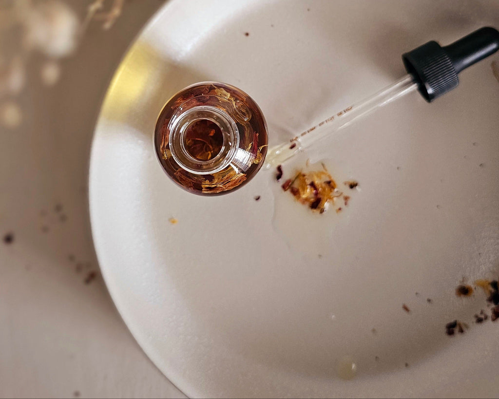 Dropper with liquid being poured onto a white surface, creating droplets.