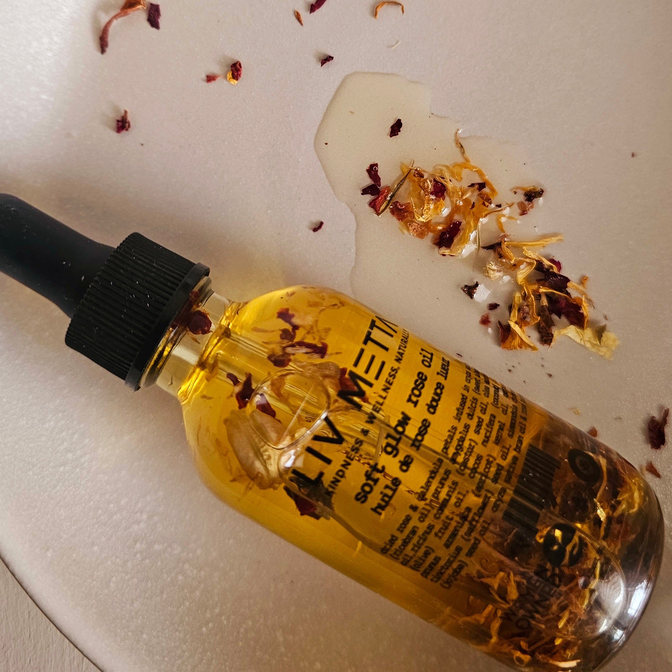 Soft Glow Rose Oil Close up with rose petals in a plate