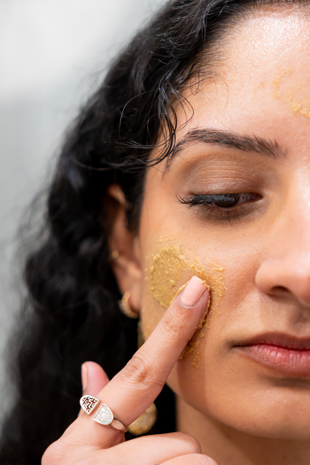 Woman applying face mask on face