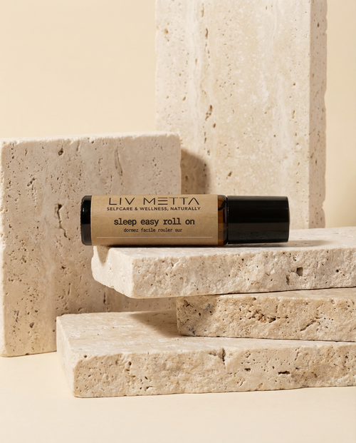 Roll-on bottle labeled 'LIV METTA sleep easy roll on' on stone steps with a neutral background